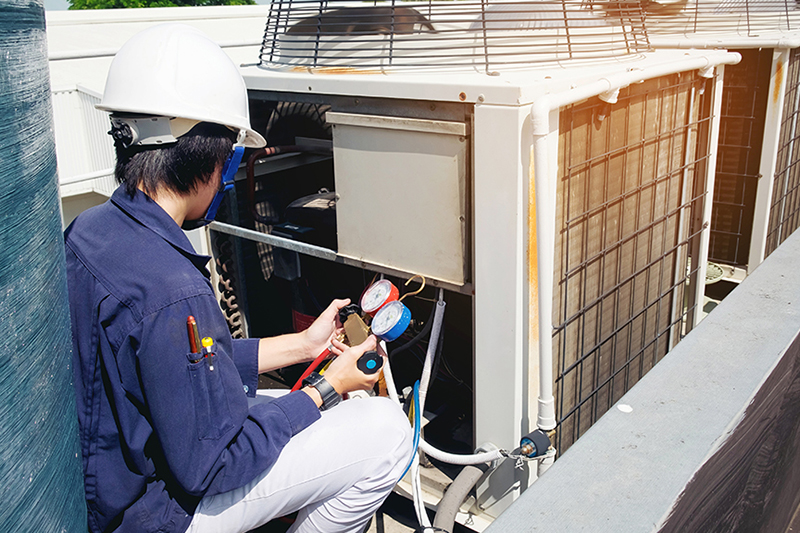 Why Is a Commercial AC Tune-Up Important? A technician working on an air conditioner.